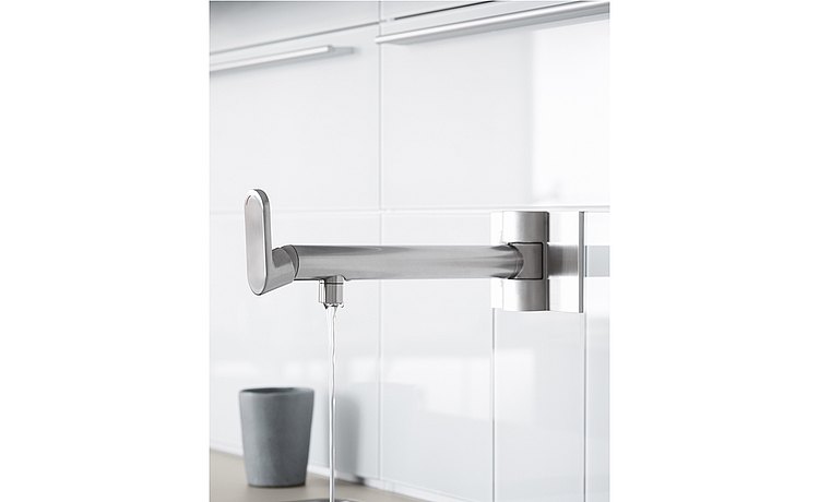 Wall-mounted, swiveling faucet at the water point