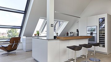 Die alpinweiße bulthaup b3 fügt sich perfekt in die Münchner Dachgeschosswohnung ein.
