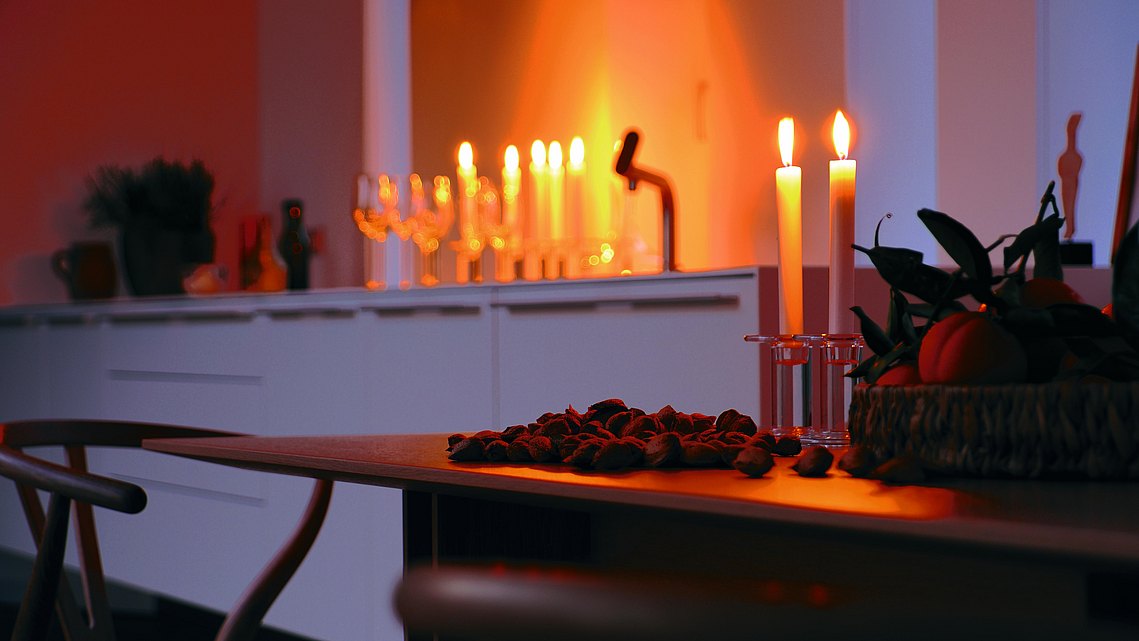 bulthaup Esstisch mit Kerzen und einer bulthaup b3 im Hintergrund.