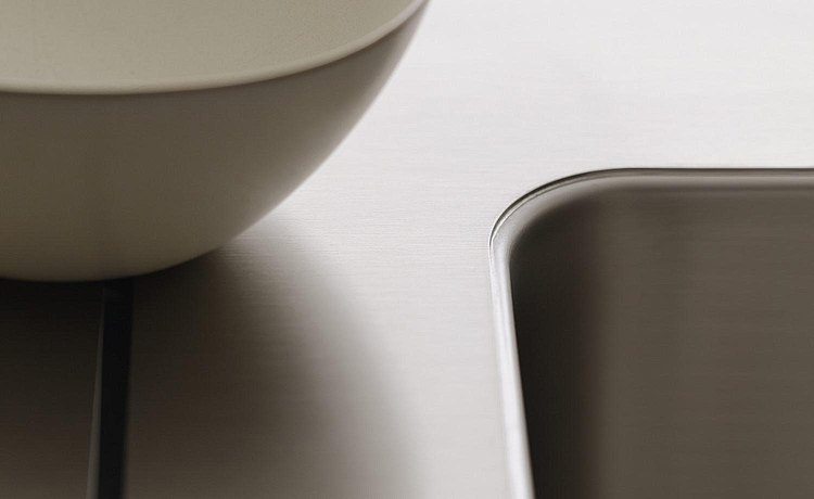 Close-up: brushed stainless steel water point, integrated seamlessly into the workbench