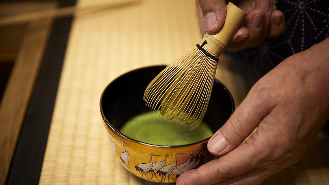 Mit einem speziellen Besen aus Bambus wir der Tee schaumig aufgeschlagen.