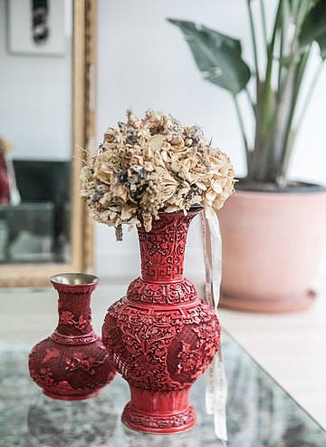 Les vases rouges avec le bouquet de mariage d'Elien.