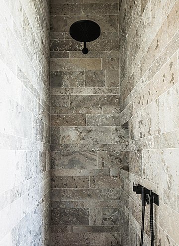 La douche est entièrement revêtue de pierre naturelle Pierre De Varennes.