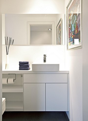Zimmer mit weißem Waschbecken und bulthaup Unterschränken.