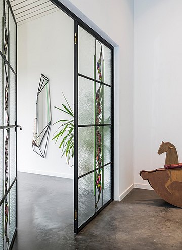 Spiegel 'Retrospekt' en glasraam in deur met florate motieven.
